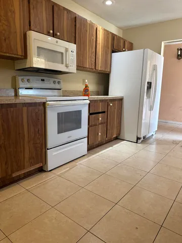 a kitchen with a stove a refrigerator and a cabinets