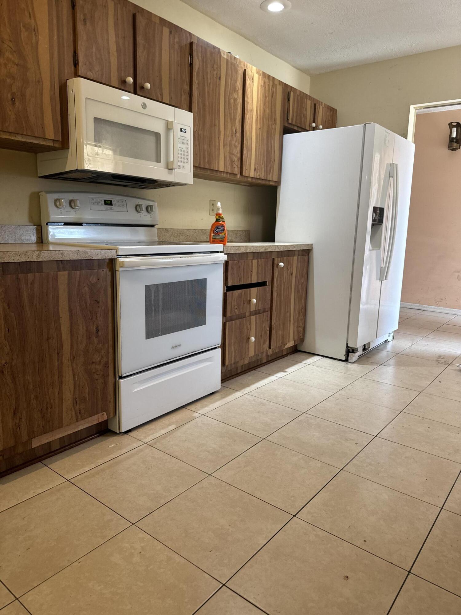 952 Southeast Walters Terrace Port St. Lucie, FL 34983 - Photo 7 of 14 a kitchen with a stove a refrigerator and a cabinets