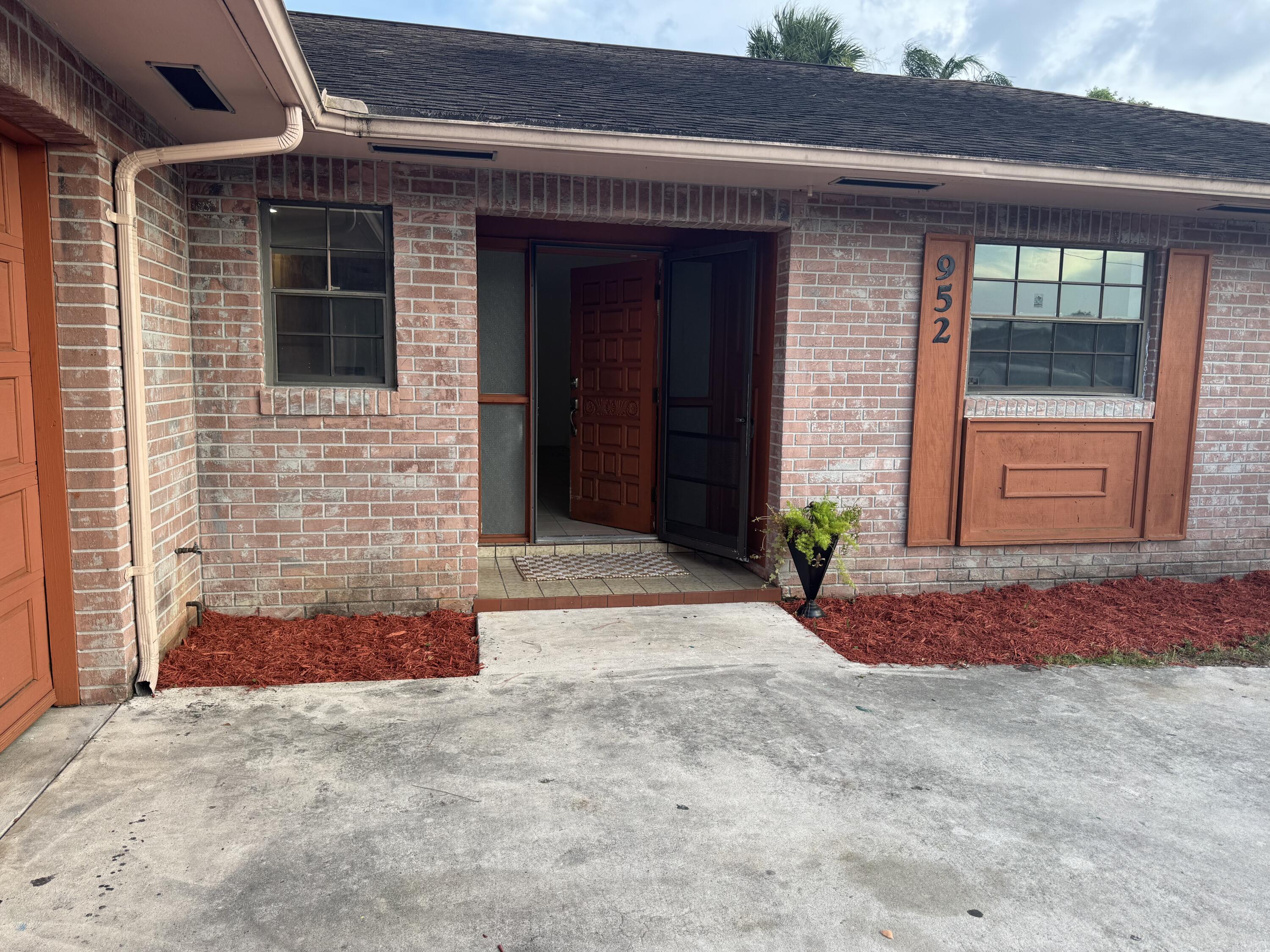 952 Southeast Walters Terrace Port St. Lucie, FL 34983 - Photo 8 of 14 a front view of a house with a yard