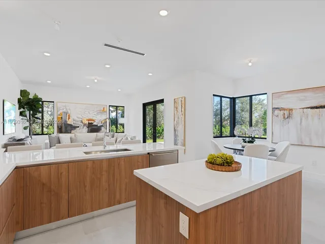 a living room with furniture a flat screen tv and a floor to ceiling window