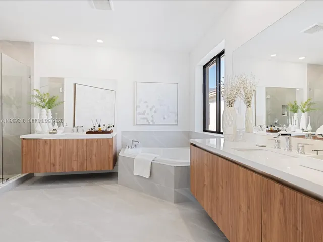 a kitchen that has a sink a microwave oven a stove and white cabinets with wooden floor