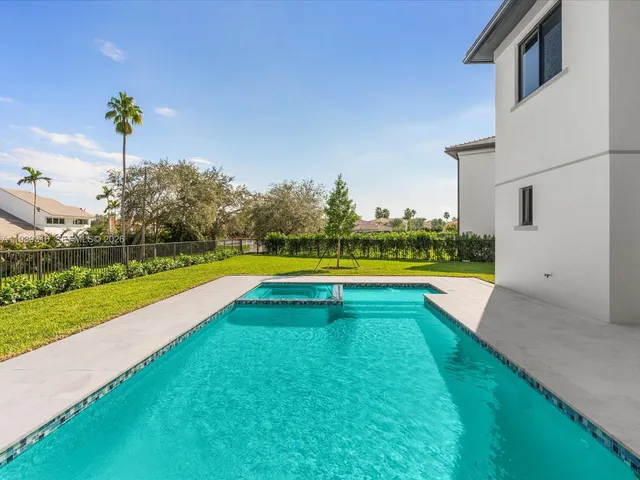 a view of a hallway with wooden floor and a bathroom
