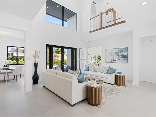 a living room with stainless steel appliances kitchen island a table and chairs