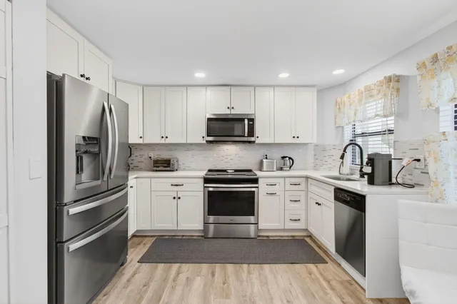 a kitchen with cabinets stainless steel appliances and a sink