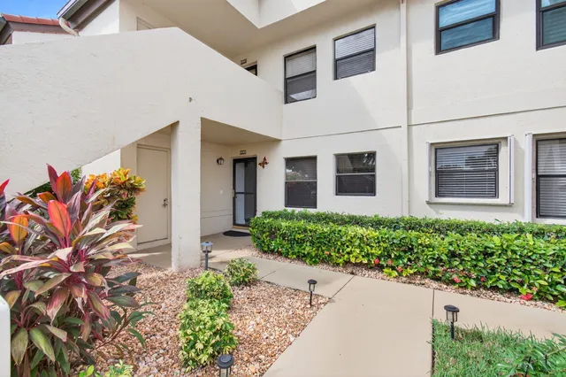 a front view of a house with a yard and plant in front of it