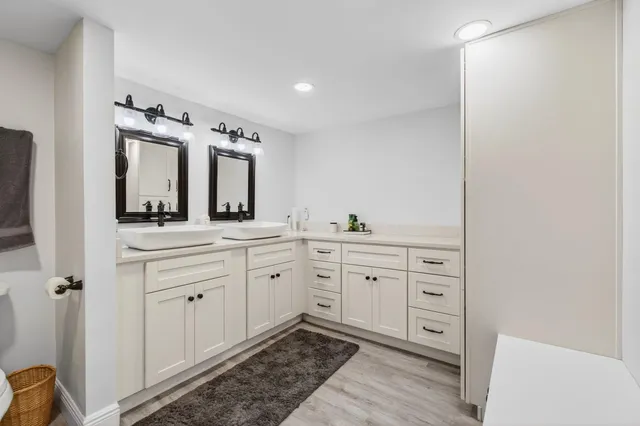 a spacious bathroom with a double vanity sink and mirror