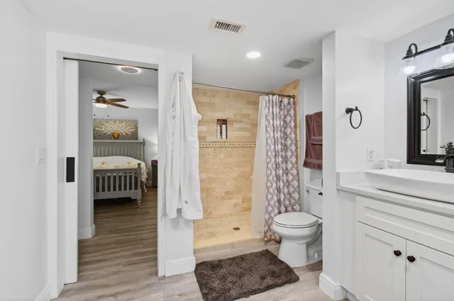 a bathroom with a shower a toilet and a window