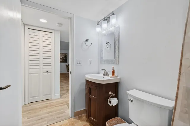 a bathroom with a toilet a sink and mirror