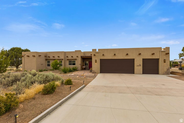 2925 Juniper Road Enterprise, UT 84725 - Photo 9 of 56 Adobe home with an attached garage, stucco siding, and driveway