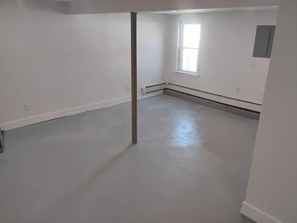 an empty room with a fireplace and window