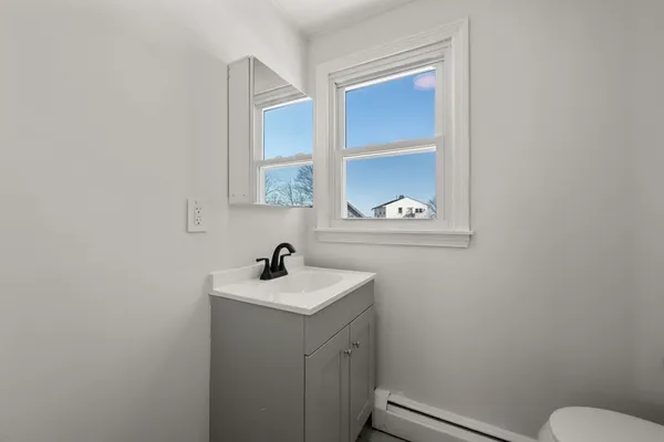 a bathroom with a sink a toilet and a window