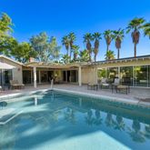 a view of a house with sitting area and swimming pool