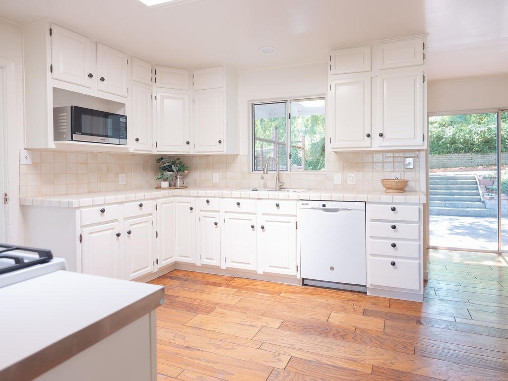 264 Upland Road Redwood City, CA 94062 - Photo 6 of 31 a kitchen with white cabinets and window