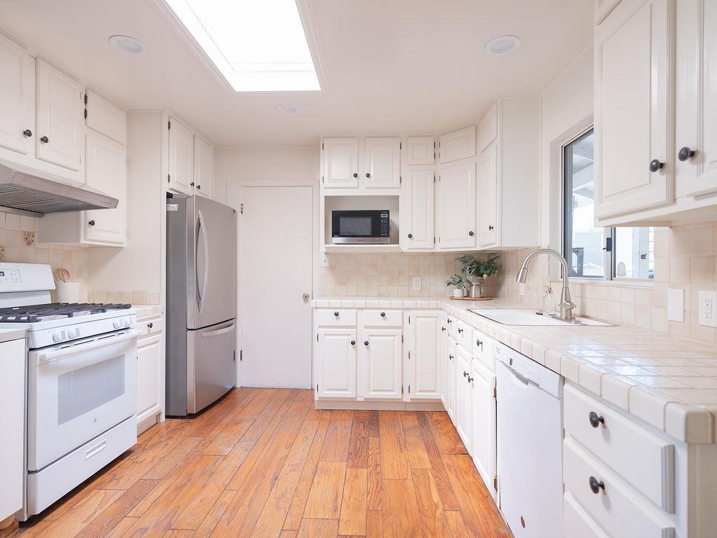 264 Upland Road Redwood City, CA 94062 - Photo 8 of 31 a kitchen with granite countertop white cabinets and white appliances