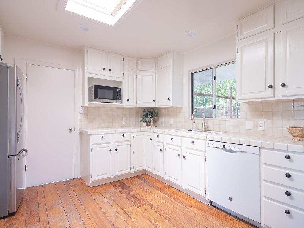 264 Upland Road Redwood City, CA 94062 - Photo 9 of 31 a kitchen with granite countertop white cabinets and white appliances