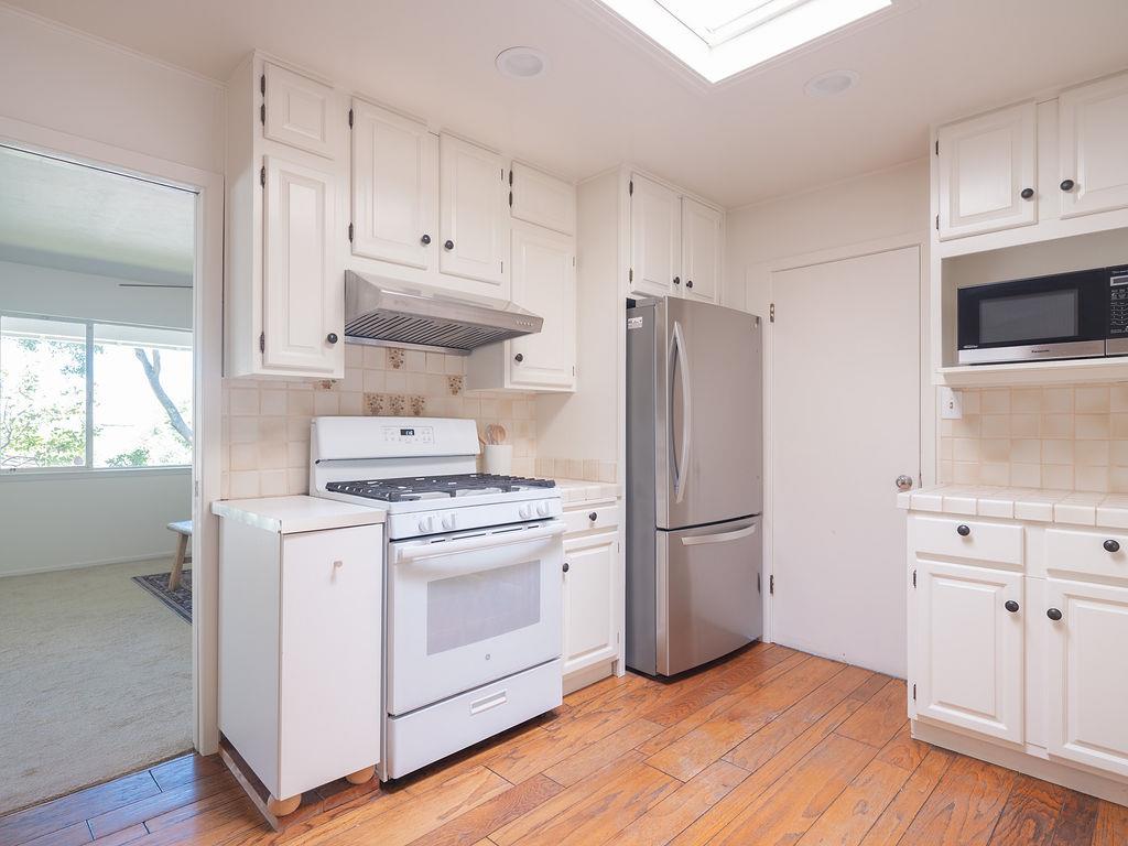 264 Upland Road Redwood City, CA 94062 - Photo 10 of 31 a kitchen with a stove a refrigerator and a sink