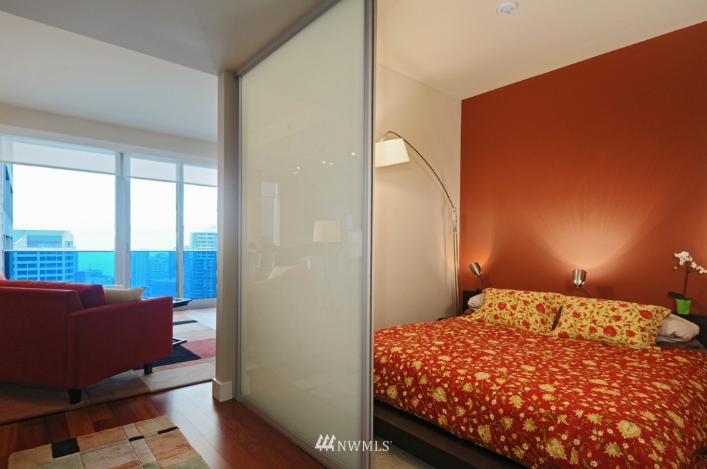737 Olive Way, Unit 2809 Seattle, WA 98101 - Photo 12 of 24 a bedroom with a bed and wooden floor