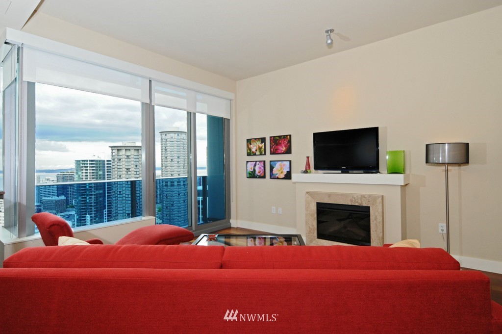 737 Olive Way, Unit 2809 Seattle, WA 98101 - Photo 3 of 24 a bedroom with a bed and a flat screen tv