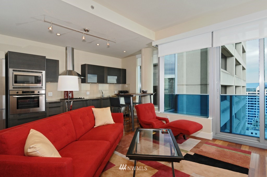 737 Olive Way, Unit 2809 Seattle, WA 98101 - Photo 5 of 24 a view of kitchen with stainless steel appliances dining table and chairs