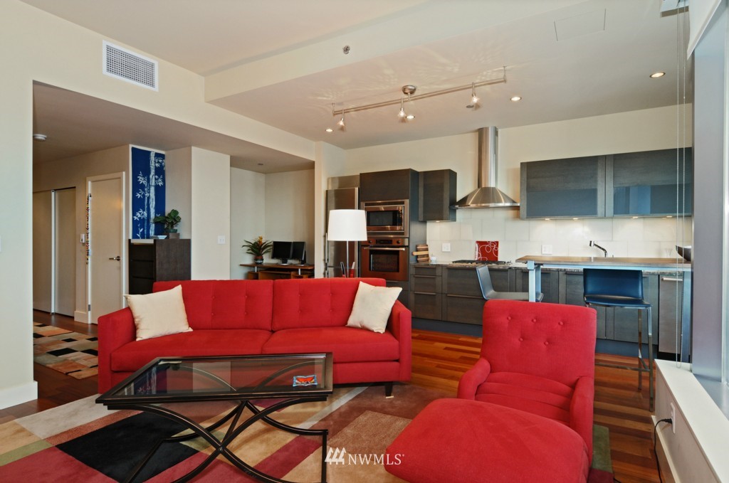 737 Olive Way, Unit 2809 Seattle, WA 98101 - Photo 6 of 24 a living room with furniture kitchen view and a fireplace