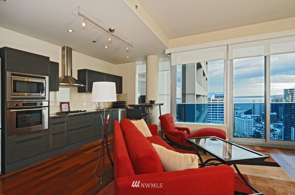 737 Olive Way, Unit 2809 Seattle, WA 98101 - Photo 7 of 24 a kitchen with stainless steel appliances kitchen island granite countertop a refrigerator and a stove top oven