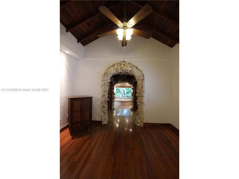 7975 Sunset Drive Miami, FL 33143 - Photo 12 of 21 a view of a hallway with wooden floor and a chandelier