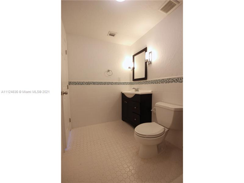7975 Sunset Drive Miami, FL 33143 - Photo 16 of 21 a bathroom with a toilet a sink and a mirror