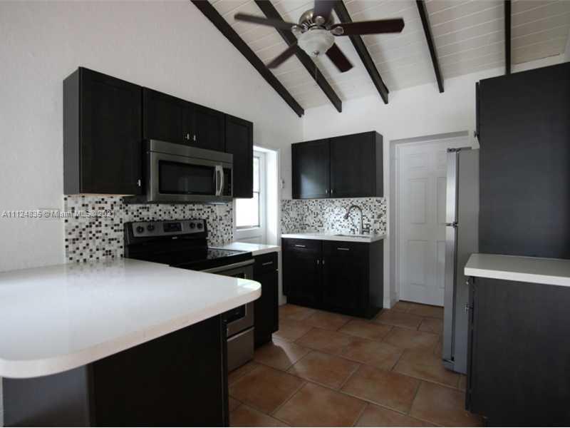 7975 Sunset Drive Miami, FL 33143 - Photo 18 of 21 a living room with furniture a flat screen tv and a fireplace