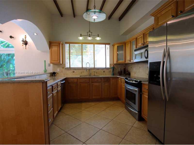 7975 Sunset Drive Miami, FL 33143 - Photo 7 of 21 a kitchen with stainless steel appliances granite countertop a sink stove and refrigerator