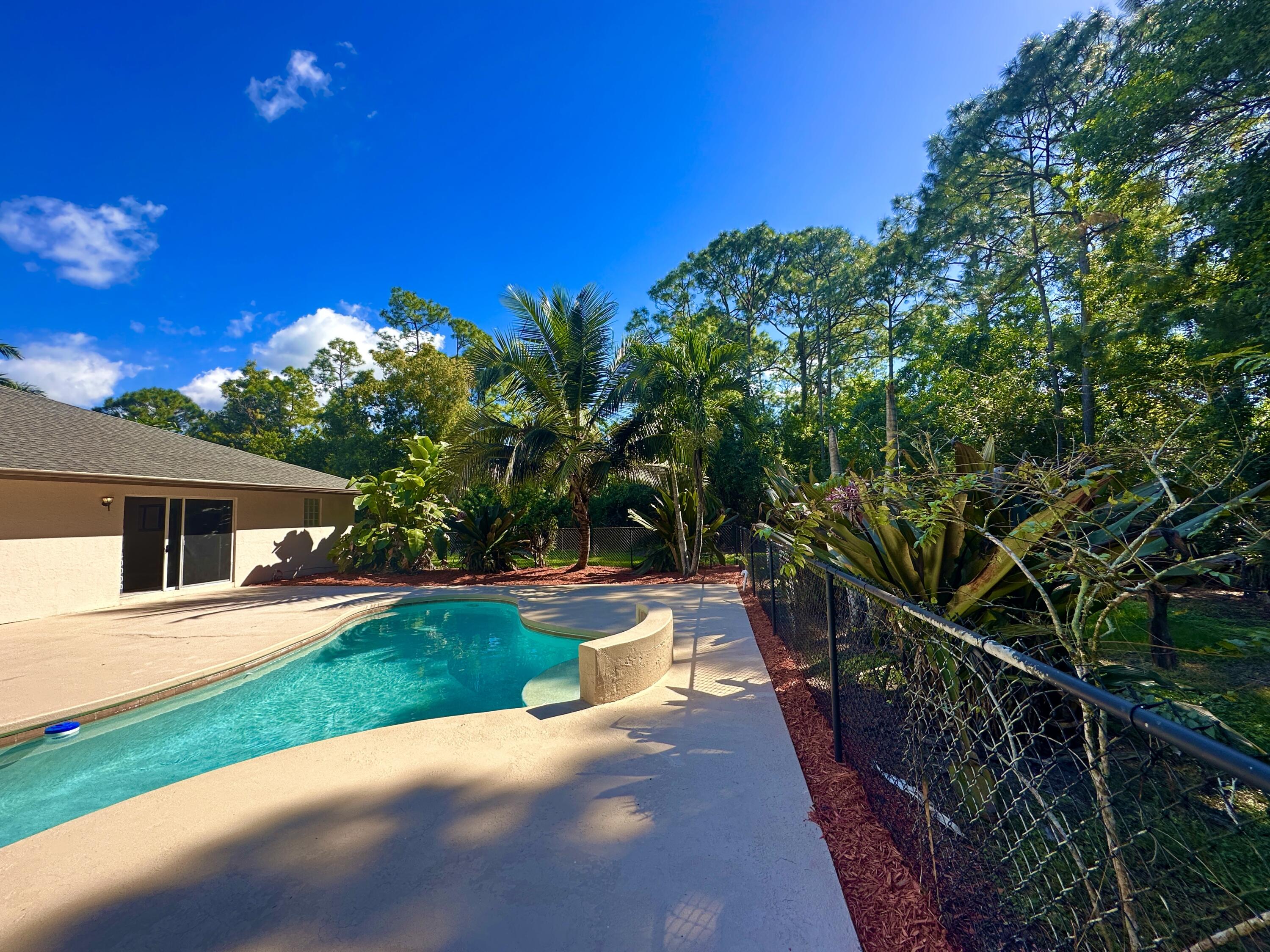 13338 76th Road North West Palm Beach, FL 33412 - Photo 14 of 138 a view of a house with backyard and a trees