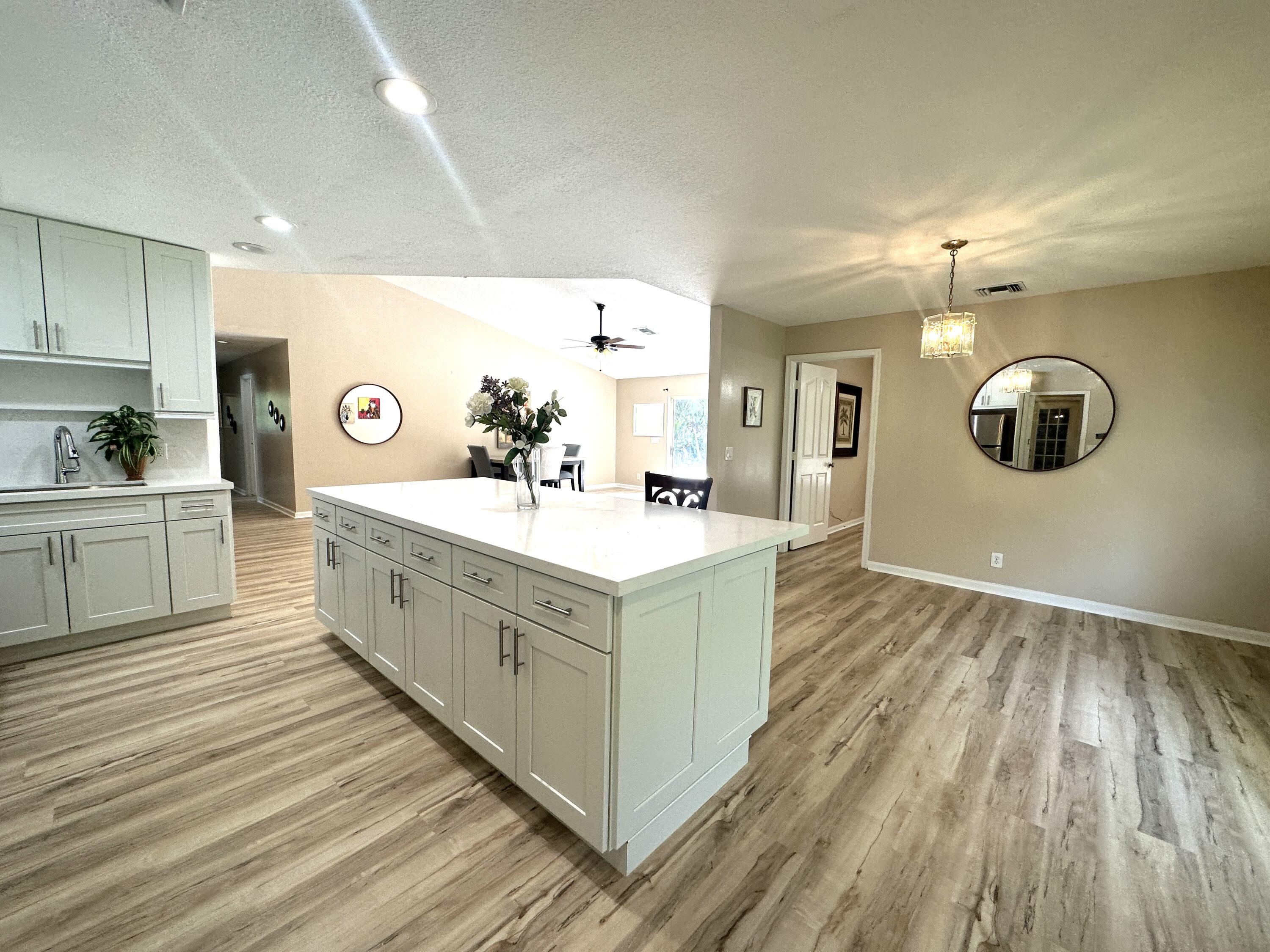 13338 76th Road North West Palm Beach, FL 33412 - Photo 22 of 138 a large white kitchen with a sink and dishwasher stove with wooden floor