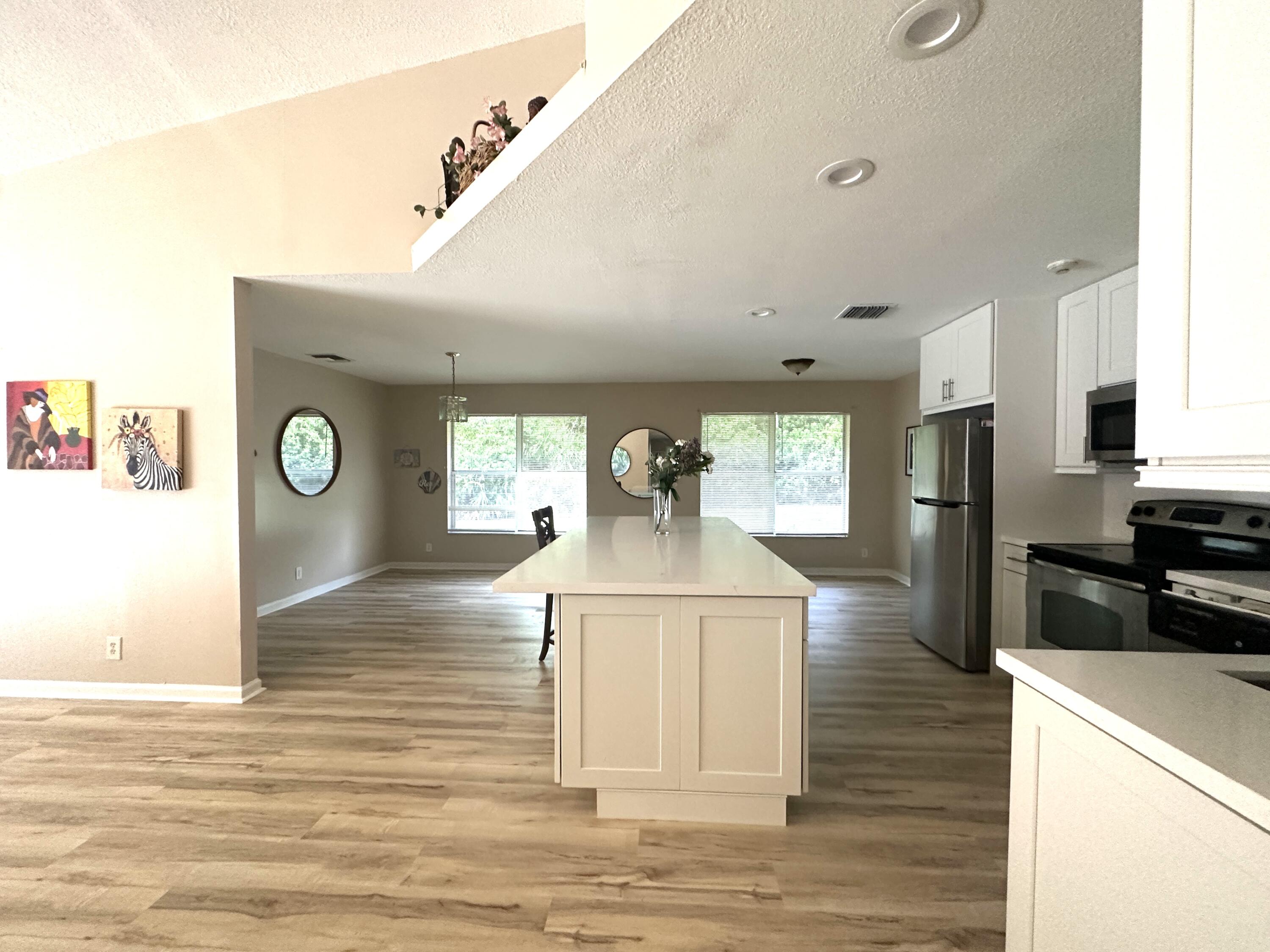 13338 76th Road North West Palm Beach, FL 33412 - Photo 37 of 138 a open kitchen with stainless steel appliances granite countertop a refrigerator a stove and a microwave with wooden floor