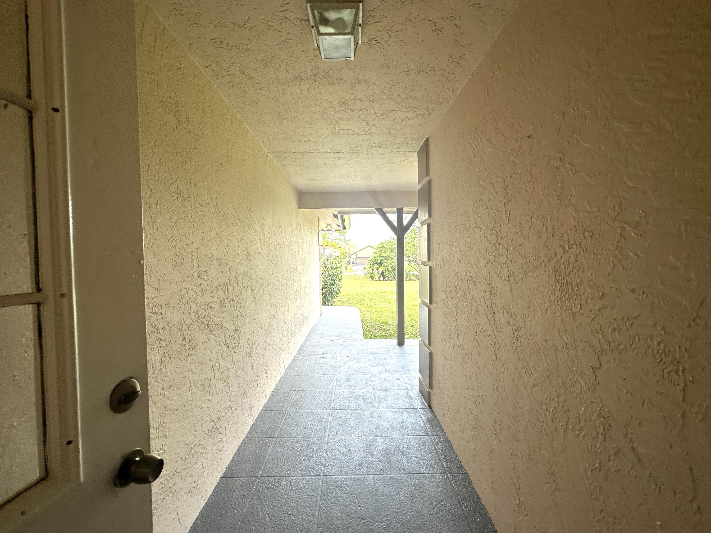 13338 76th Road North West Palm Beach, FL 33412 - Photo 38 of 138 a view of a hallway with wooden floor and a bathroom