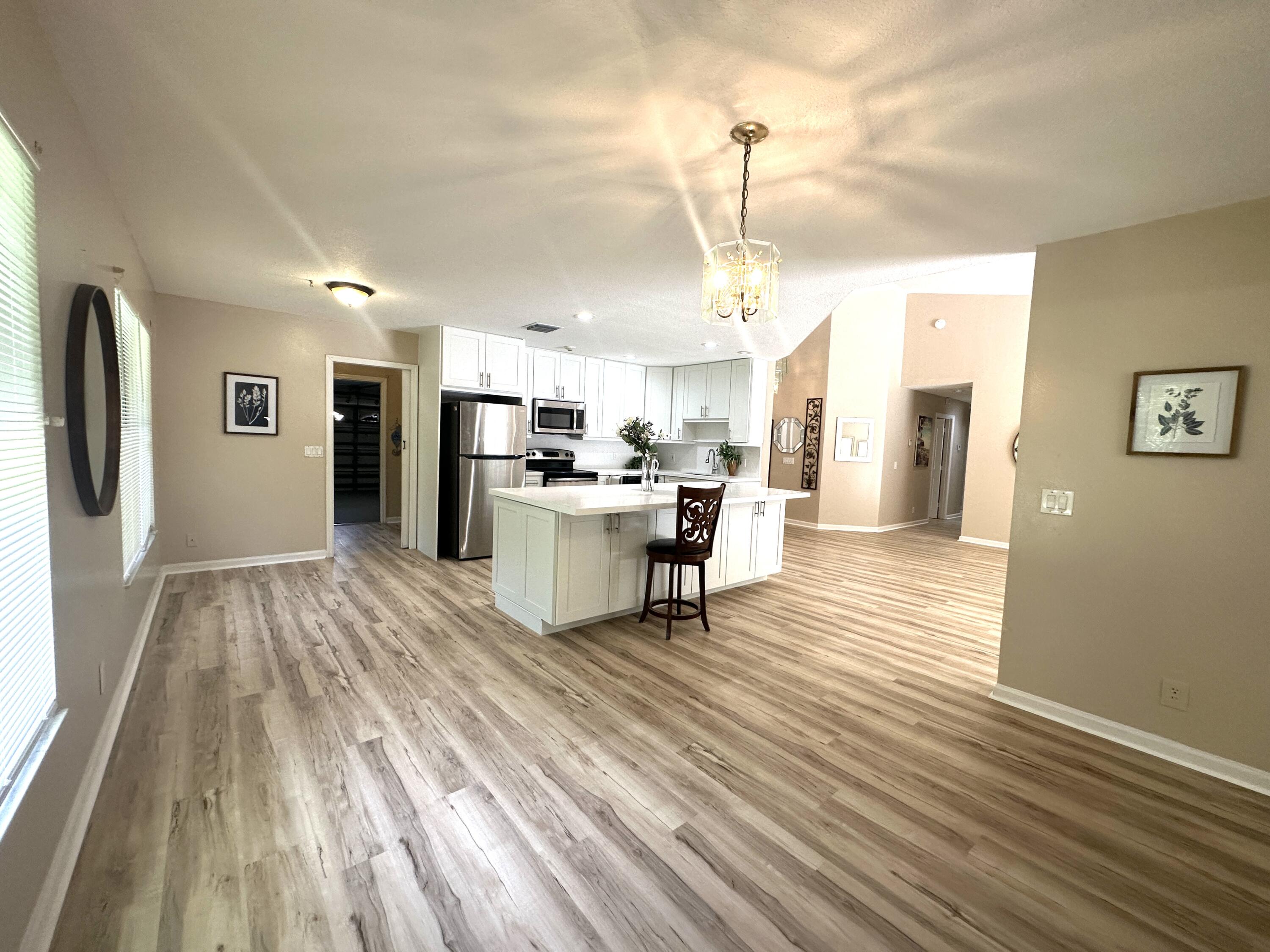 13338 76th Road North West Palm Beach, FL 33412 - Photo 50 of 138 a living room with stainless steel appliances kitchen island granite countertop furniture and a wooden floor