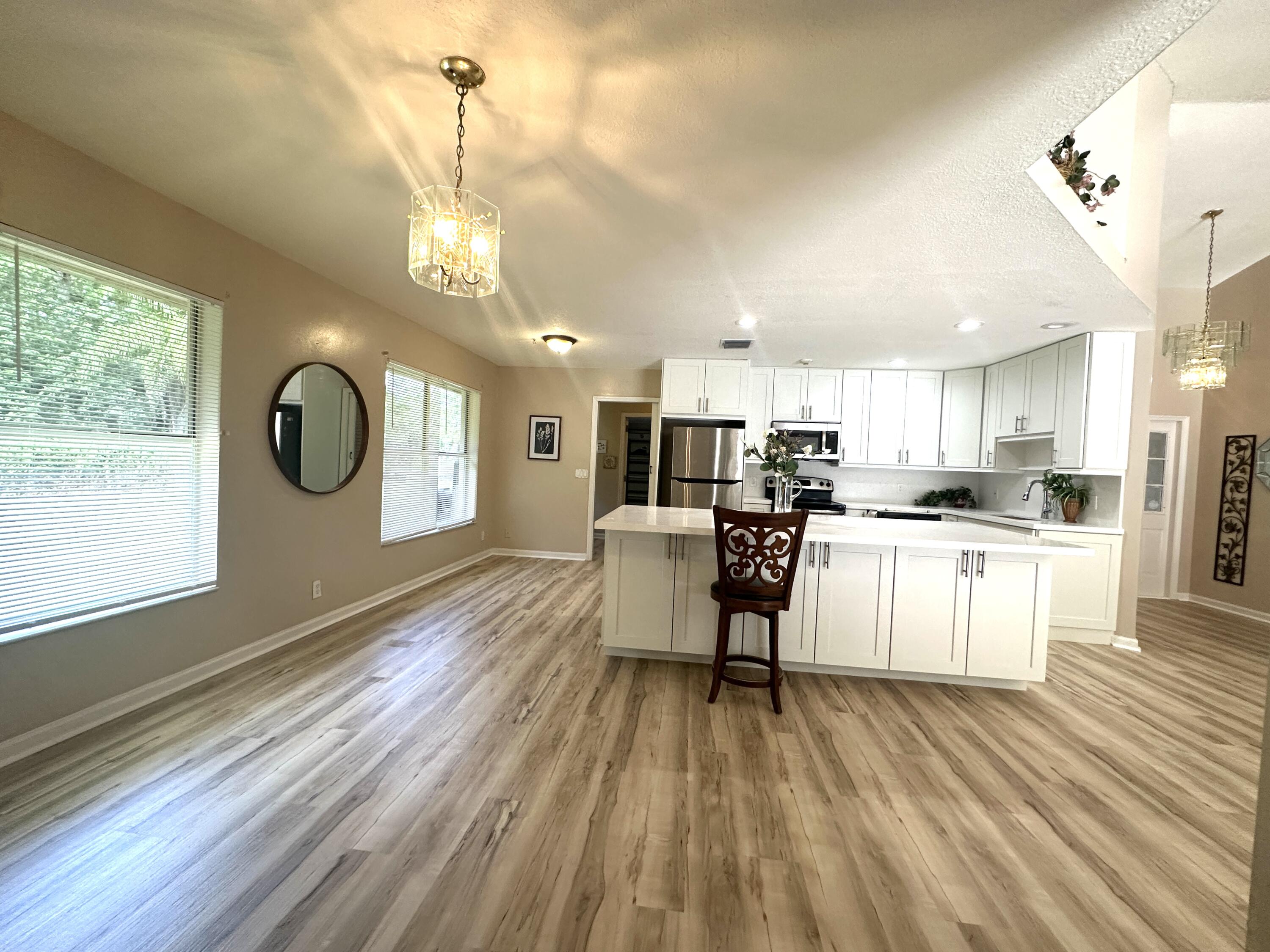 13338 76th Road North West Palm Beach, FL 33412 - Photo 53 of 138 a kitchen with stainless steel appliances granite countertop a refrigerator a stove top oven a sink dishwasher and white cabinets with wooden floor