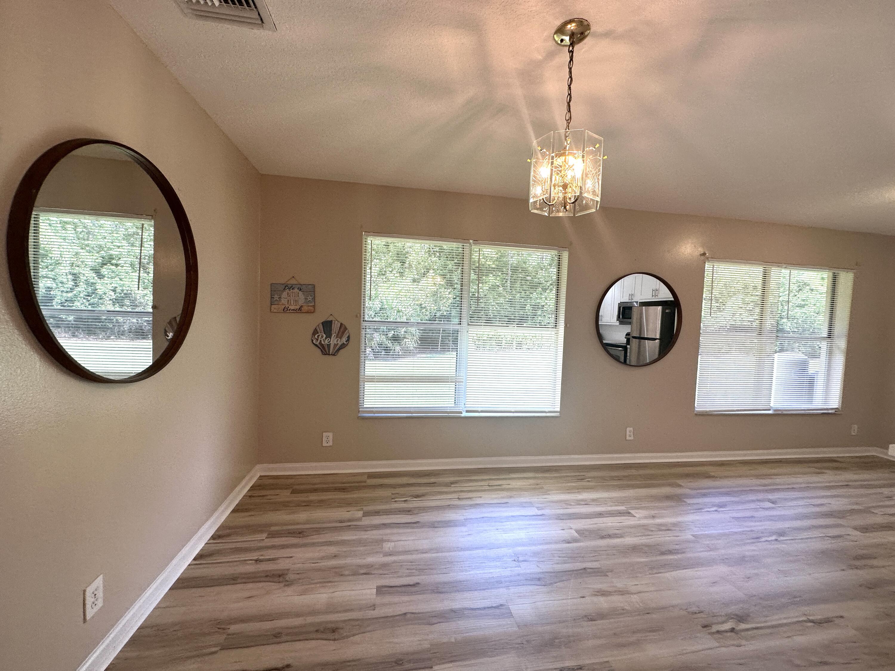 13338 76th Road North West Palm Beach, FL 33412 - Photo 58 of 138 an empty room with wooden floor windows and exposed bricks
