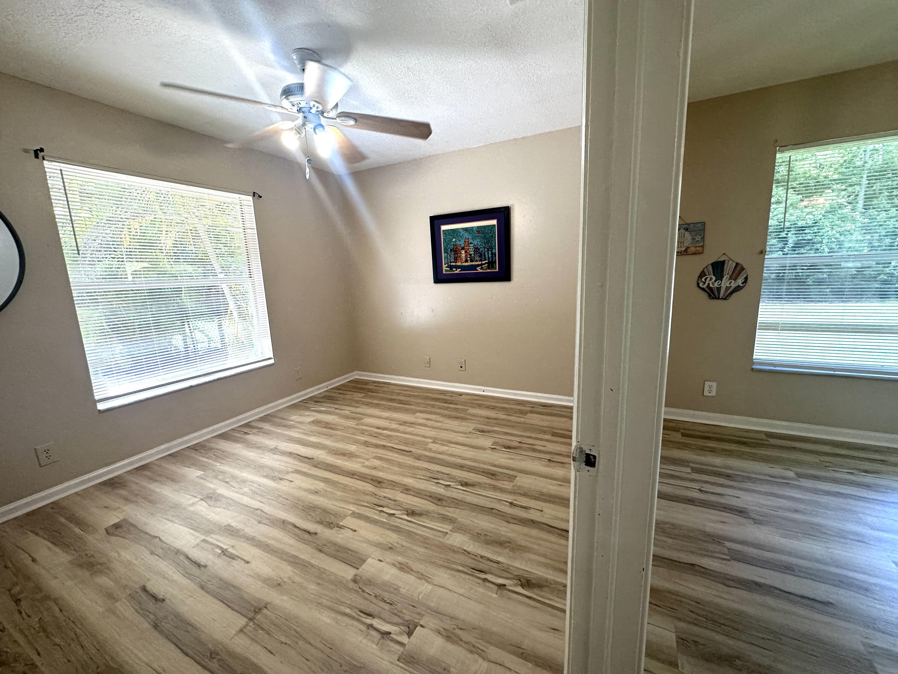 13338 76th Road North West Palm Beach, FL 33412 - Photo 59 of 138 a view of an empty room with wooden floor and a window