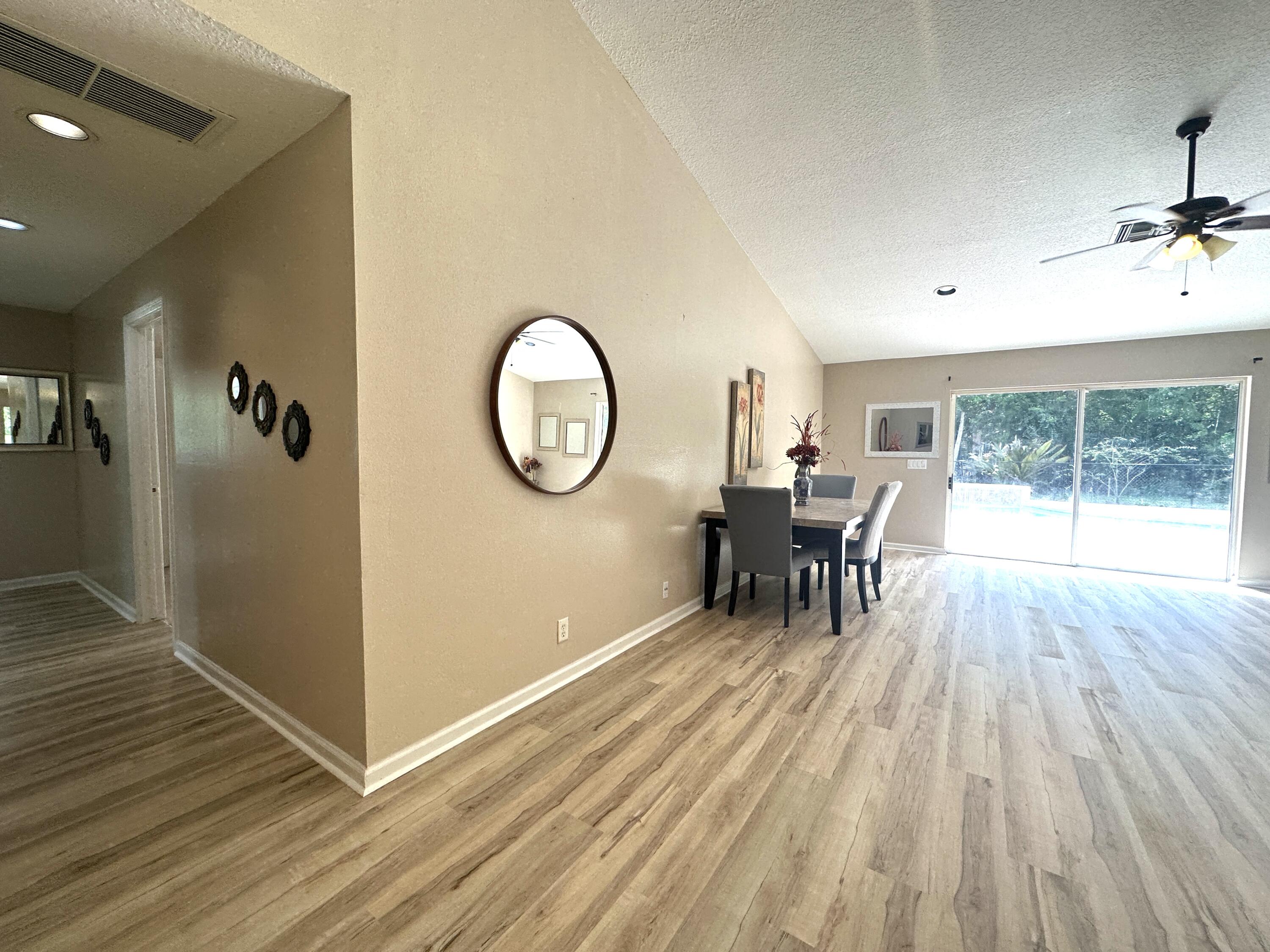 13338 76th Road North West Palm Beach, FL 33412 - Photo 60 of 138 an empty room with wooden floor mirror and windows