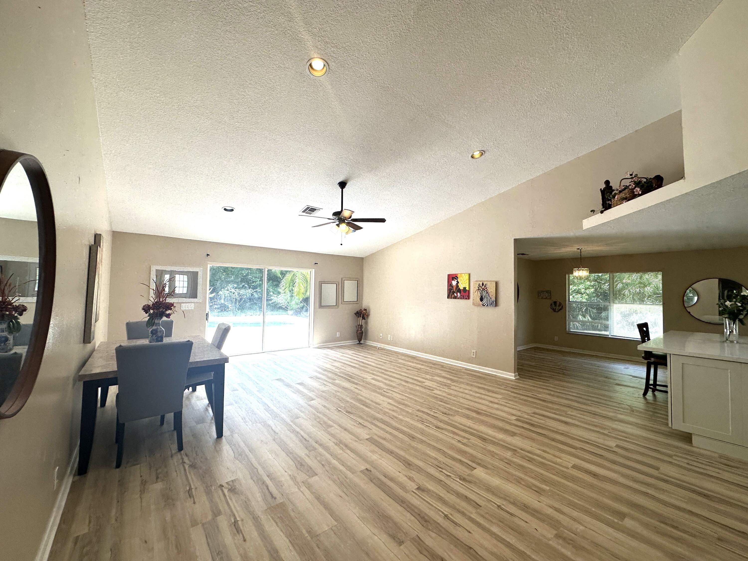 13338 76th Road North West Palm Beach, FL 33412 - Photo 64 of 138 a view of a livingroom with furniture a dinning room and wooden floor