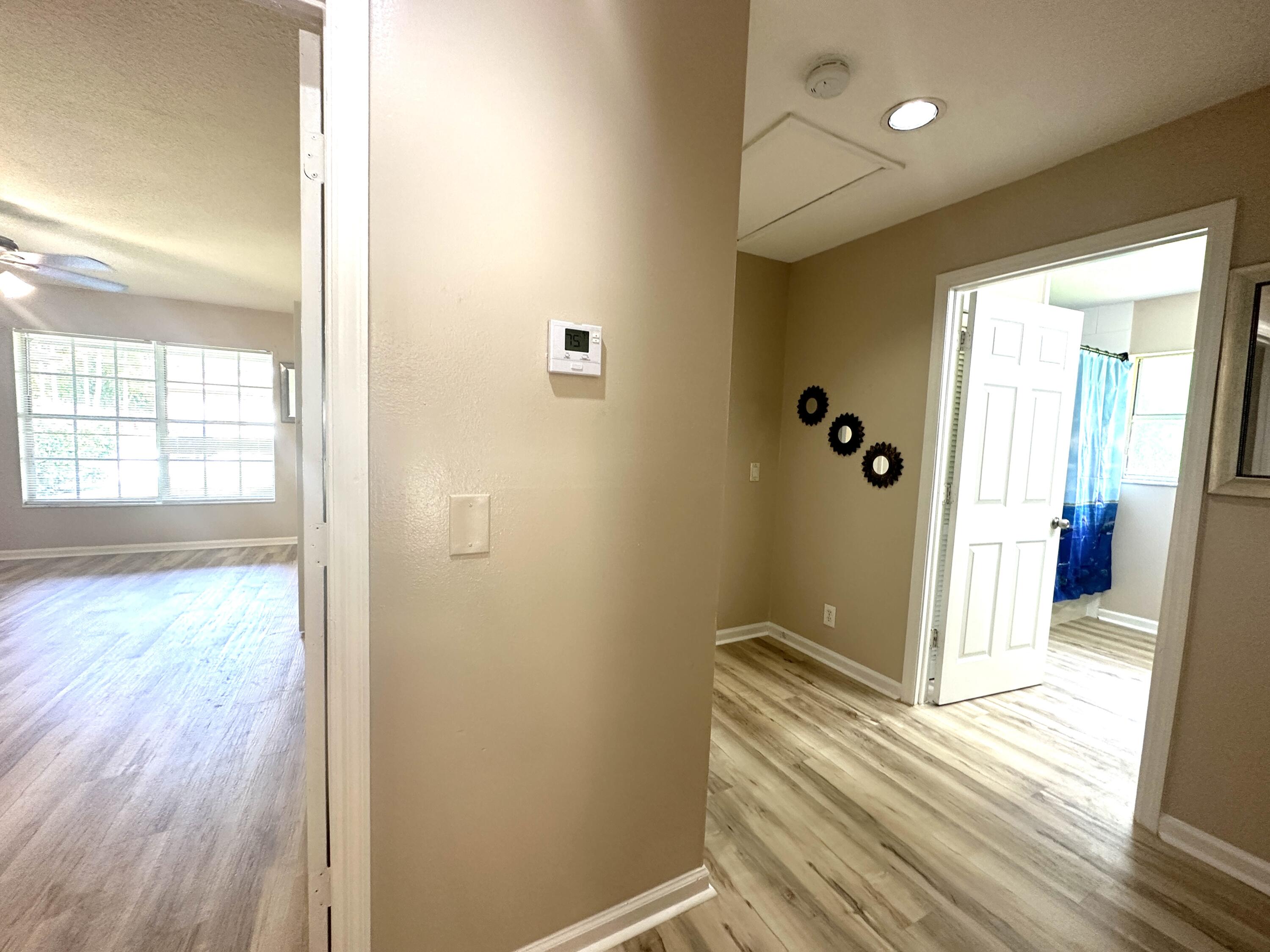 13338 76th Road North West Palm Beach, FL 33412 - Photo 72 of 138 a view of a hallway with wooden floor and a bathroom