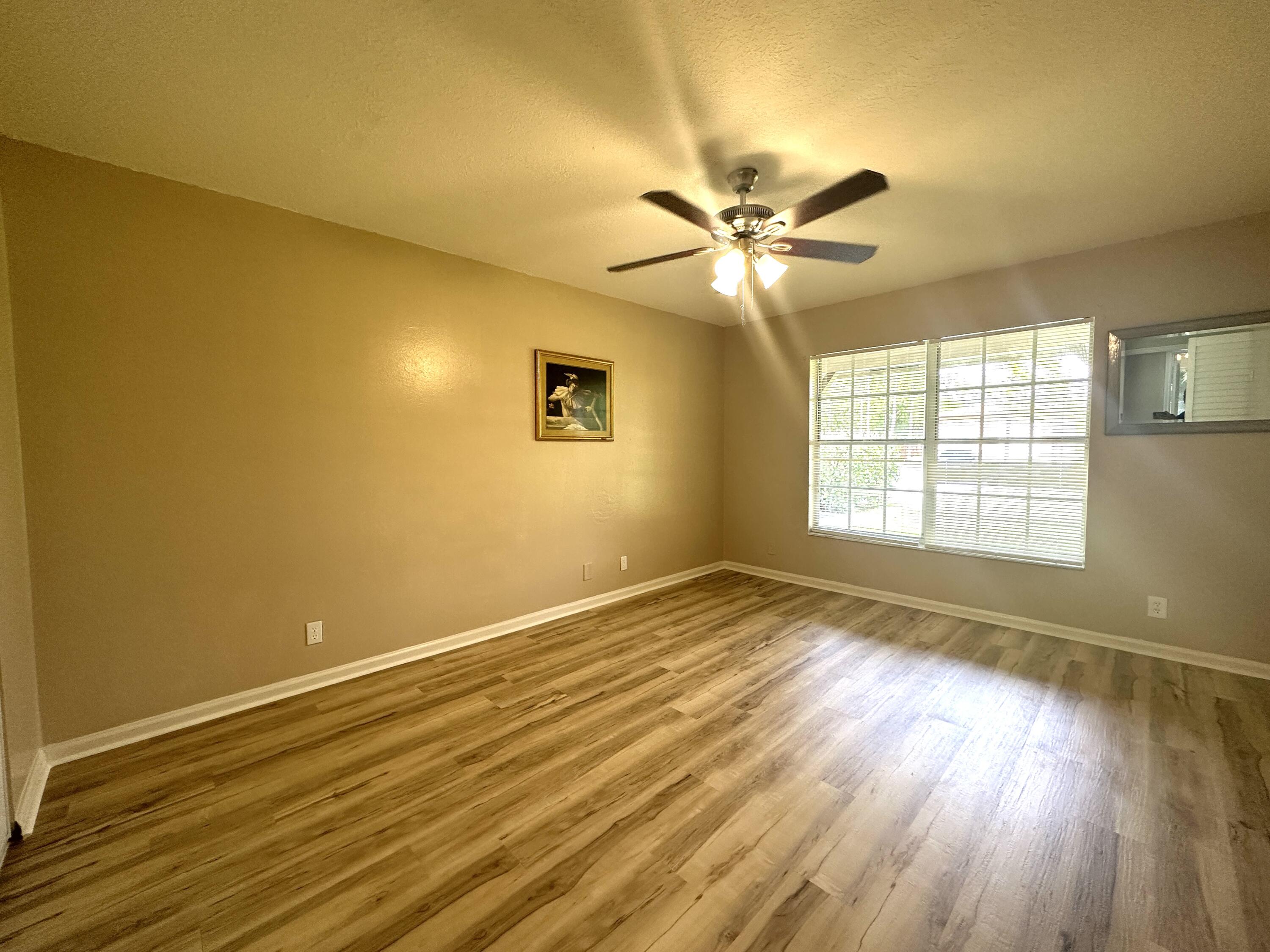13338 76th Road North West Palm Beach, FL 33412 - Photo 74 of 138 a view of empty room with wooden floor and fan
