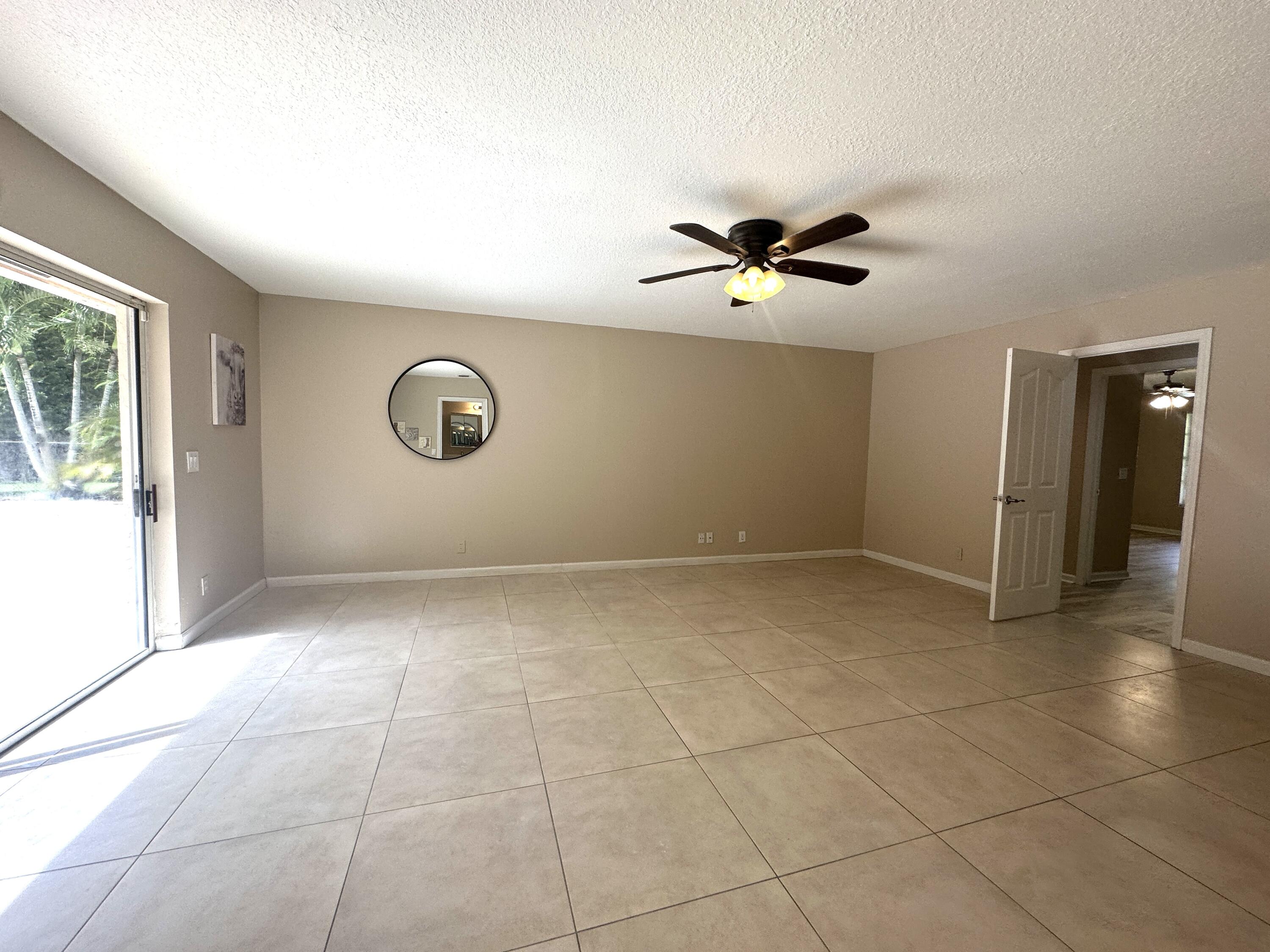 13338 76th Road North West Palm Beach, FL 33412 - Photo 76 of 138 a view of an empty room with a ceiling fan and window