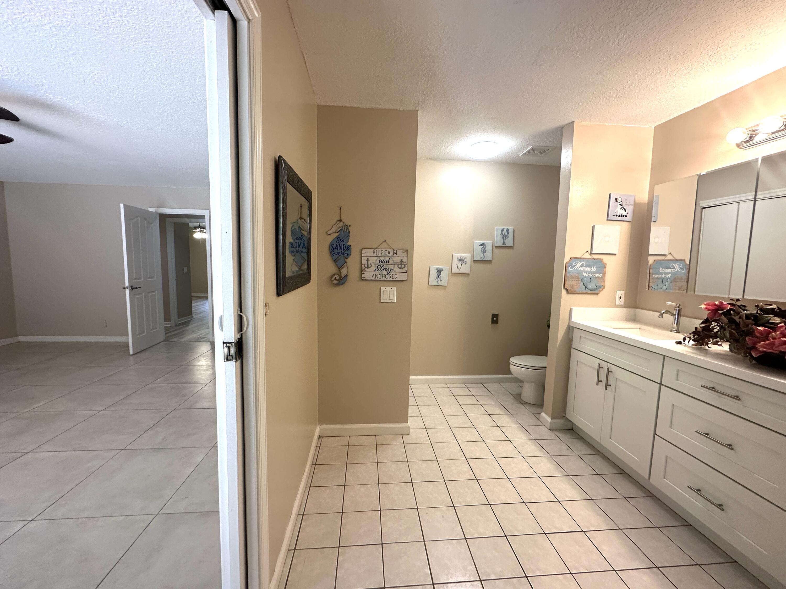 13338 76th Road North West Palm Beach, FL 33412 - Photo 78 of 138 a spacious bathroom with a double vanity sink a toilet a mirror and shower