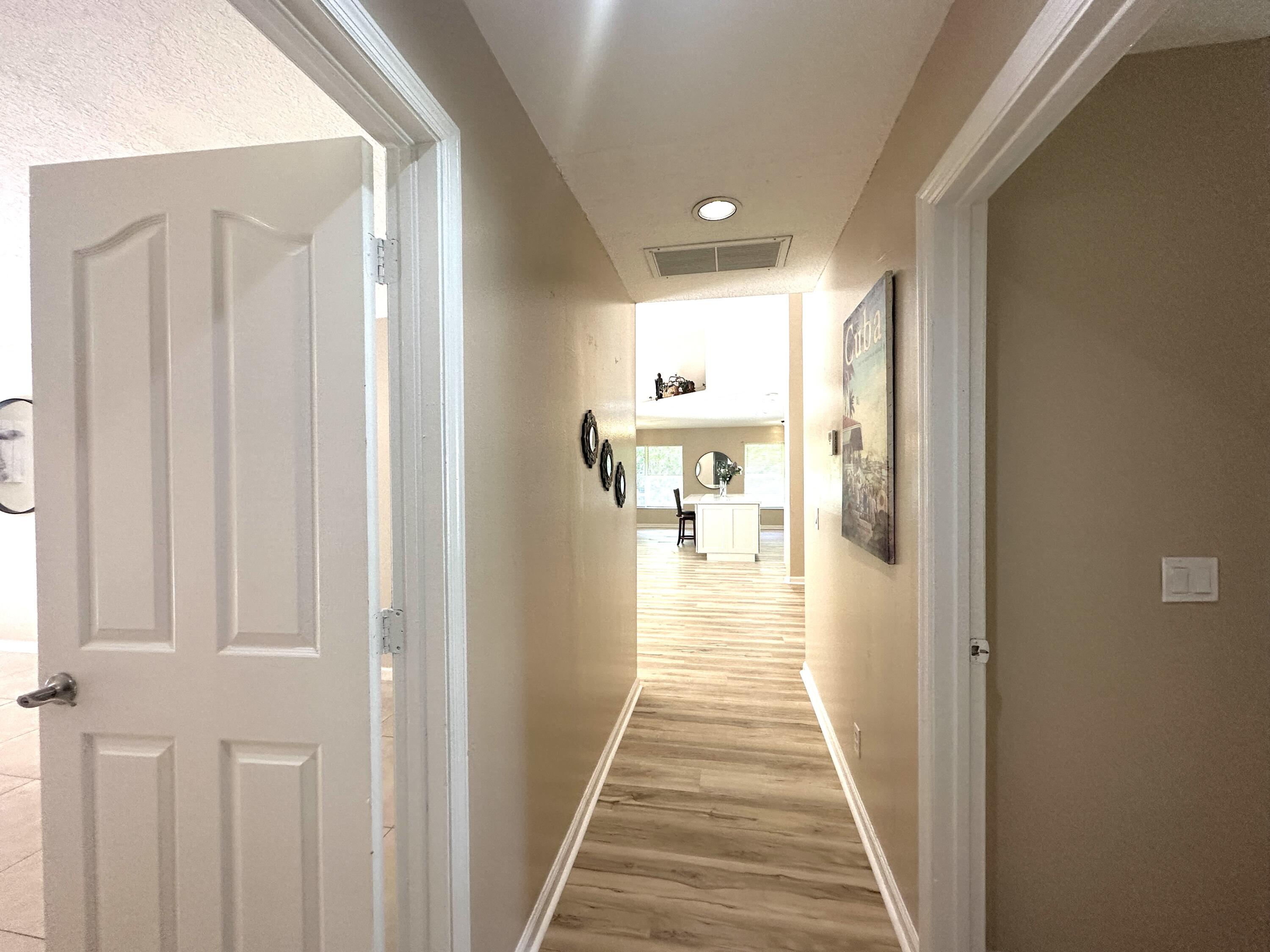 13338 76th Road North West Palm Beach, FL 33412 - Photo 93 of 138 a view of a hallway with wooden floor and a bathroom