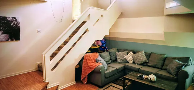 a living room with furniture and a painting on the wall