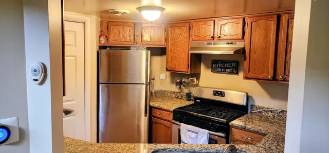a kitchen with stainless steel appliances granite countertop a refrigerator and a stove