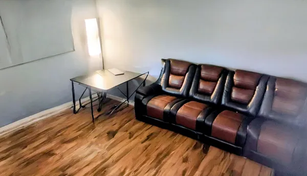 a living room with furniture and wooden floor