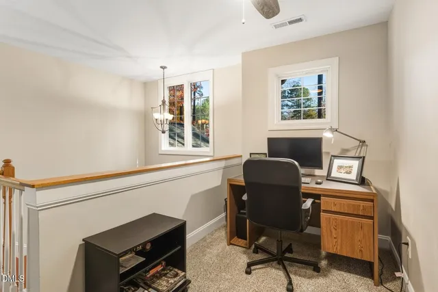 a view of a workspace with furniture and a window