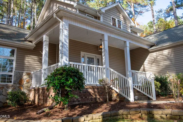 a front view of a house with a tree