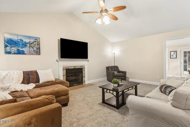 a living room with furniture a fireplace and a flat screen tv
